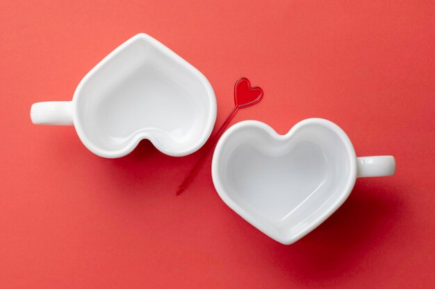 White empty heartshaped cups on a red backgroundTop viewMockup template