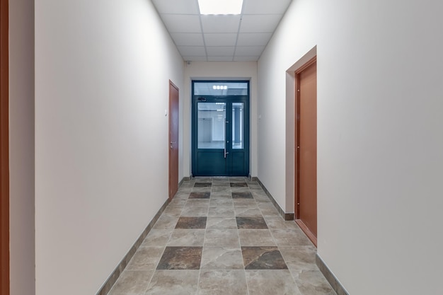 Foto lungo corridoio vuoto bianco con pareti in mattoni rossi per l'ufficio della stanza all'interno dell'ufficio o della clinica degli appartamenti moderni