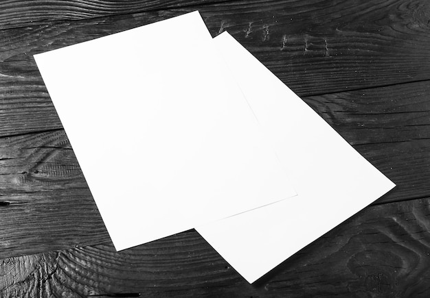 White empty papers on dark wooden background