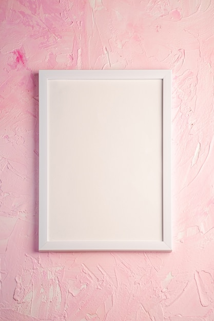 White empty picture frame on pink surface