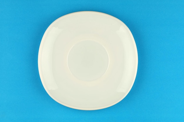 White empty plate on blue