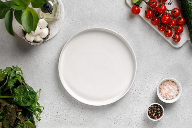 White empty plate Ingredients for salad cucumber slice tomatoes mozzarella mix salad Top view