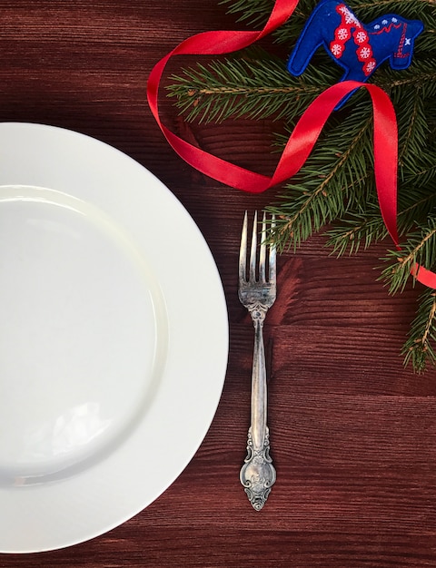 White empty plate with  fork on a table