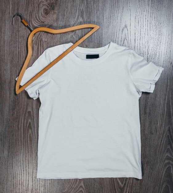 White empty t-shirts with wooden hanger on grey space