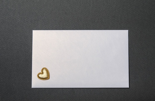 White envelope and golden hearts on a black top