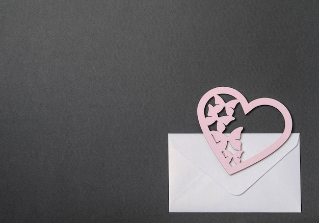 Белый конверт, розовая открытка и сердечки