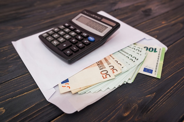 White envelope with euro banknotes and calculator