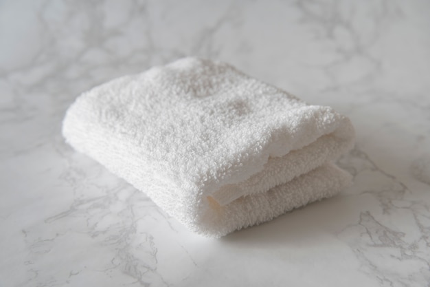 White face towel placed on a table made of white marble