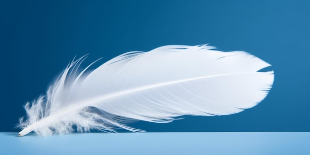 A white feather is laying on a blue table.