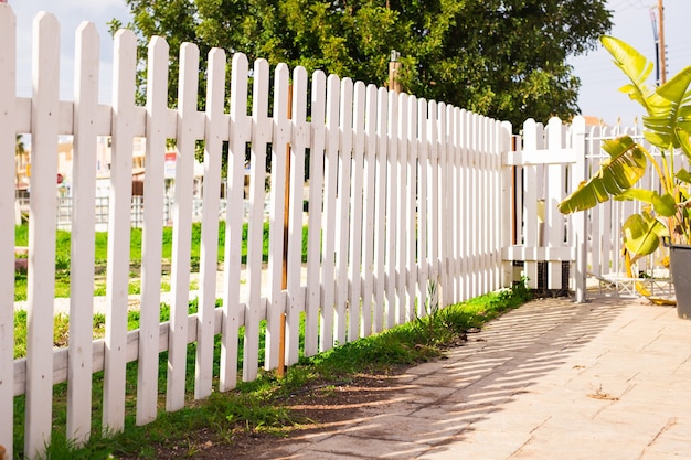 White fence in perspective and green grass