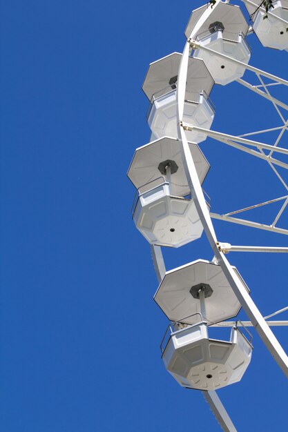 Ruota panoramica bianca sul cielo blu posizione verticale copia spazio.