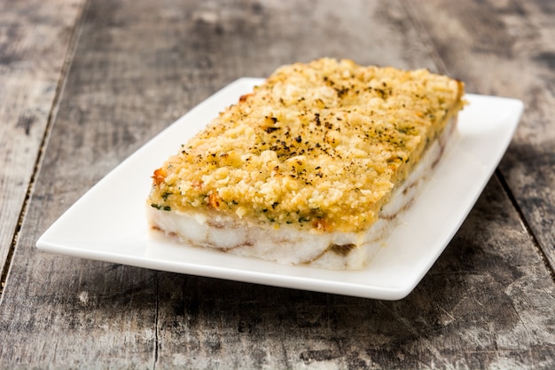 White fish casserole with cheese on wooden.