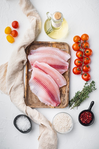 Filetto di pesce bianco, con riso basmati e pomodorini, su tavola bianca, vista dall'alto