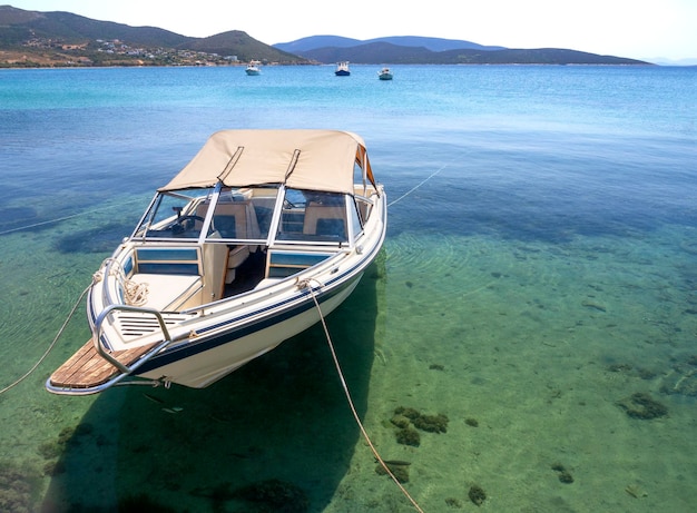 ギリシャのマルマリのギリシャのリゾートタウンの港で日よけ付きの白い漁船