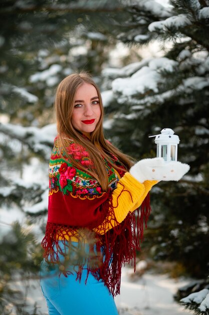 Photo a white flashlight in the hands of a ukrainian woman warm women's clothing in winter sunset behind