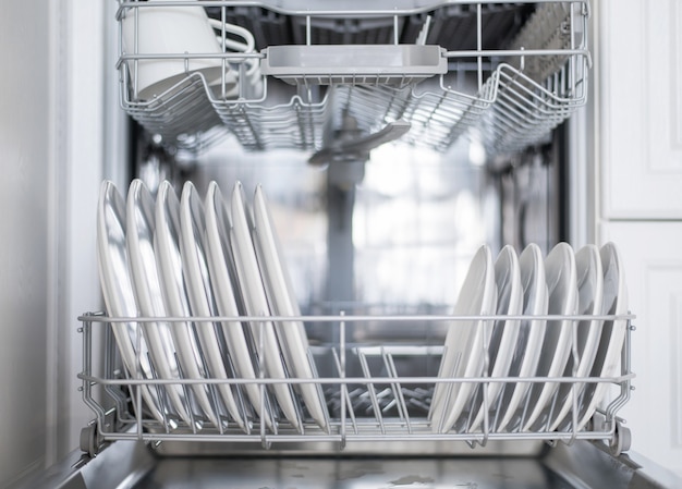 Photo white flat plates large and small are loaded into the dishwasher