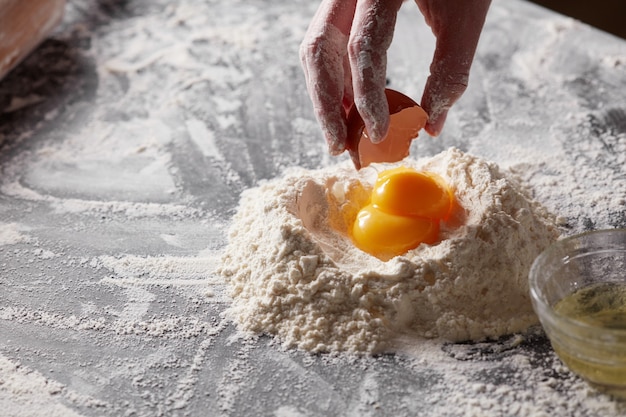 Farina bianca e tuorlo su un tavolo da cucina scuro