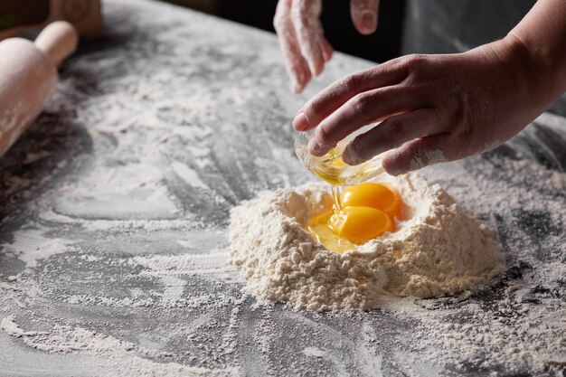 White flour and yolk on a dark kitchen table