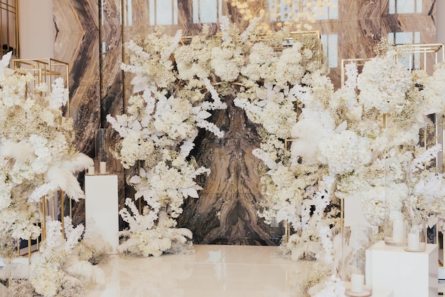 写真 白い花のアーチ結婚式の宴会場のトレンドは大理石の背景です