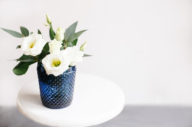 White flowers in classic blue glass. Lisianthus. Eustoma.