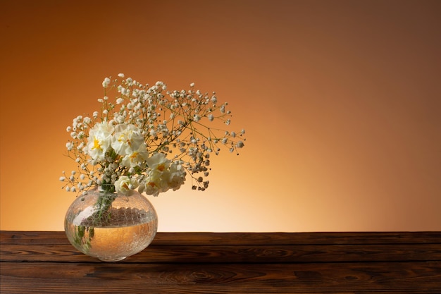 White flowers in glass vase on wooden table