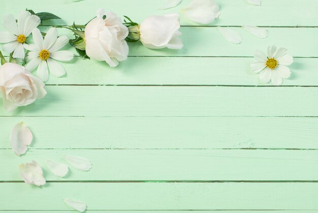 white flowers on a green wooden background