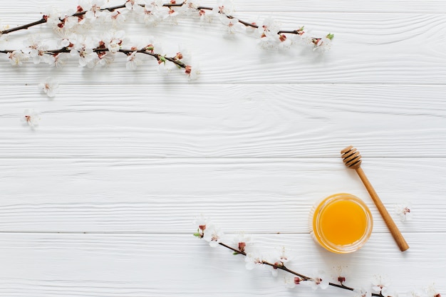 white flowers and honey on wooden background