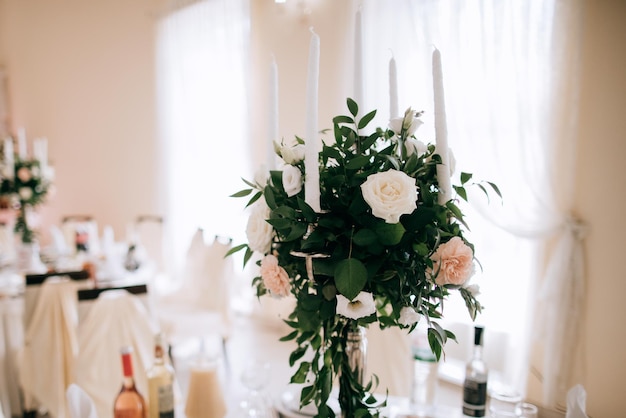 写真 レストランの結婚式のテーブルの上の白い花お祝いの夕食のためにレストランを飾る