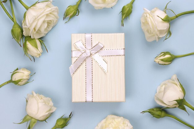 White flowers and present or gift box on blue pastel table top view greeting card for fathers day