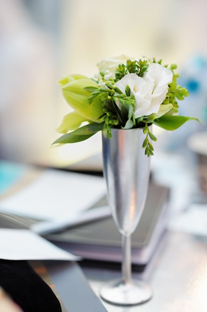 White flowers in silvery vase as decoration on the table