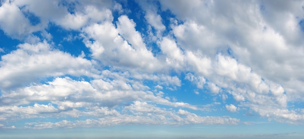 White fluffy clouds in the blue azure sky. Summer good weather background.