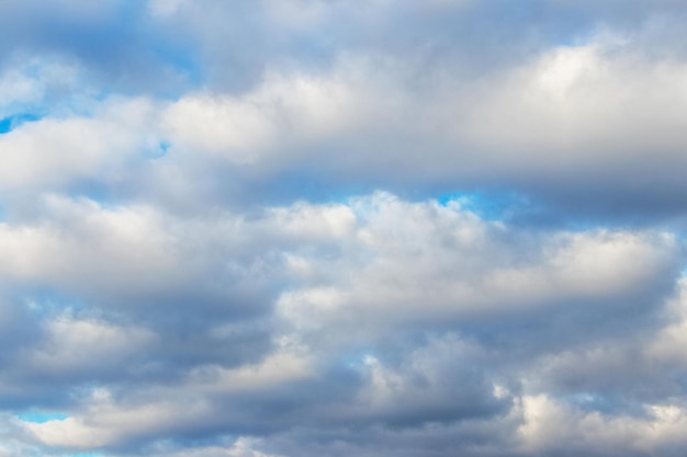 White fluffy clouds densely cover the blue sky