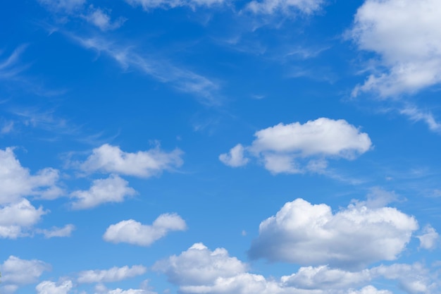 white fluffy clouds standing out against a black background and a blue sky