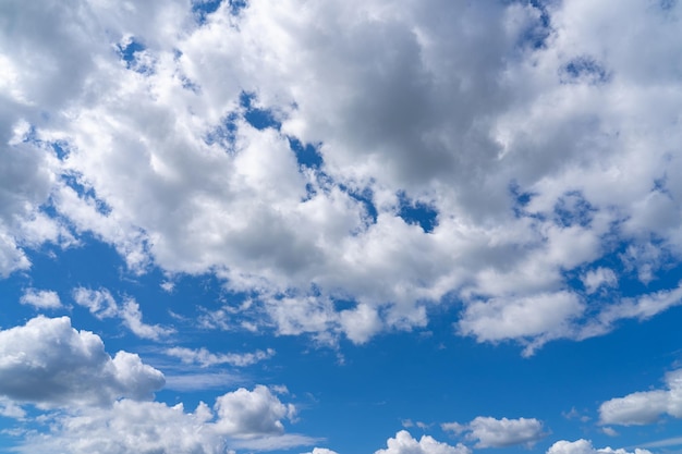 白いふわふわの雲が黒い背景と青い空に立っています