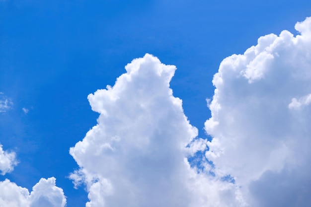 Белые пушистые кучевые облака на солнечном голубом небе