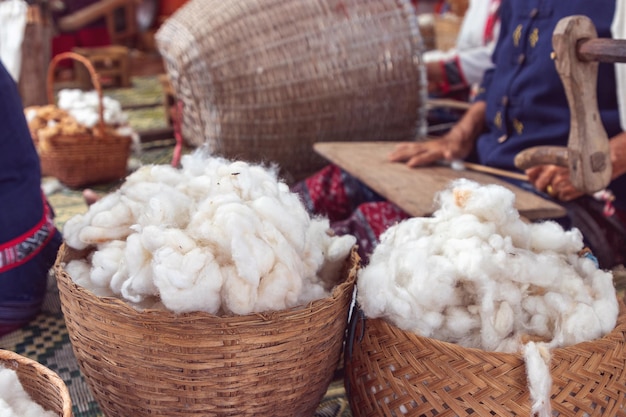 写真 地元の織物生産のための繊維と糸として以前は木製のバスケットに入った白いふわふわの有機原綿