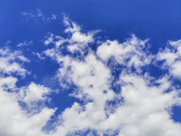 White fluffy volumetric cumulus clouds against a bright blue sky