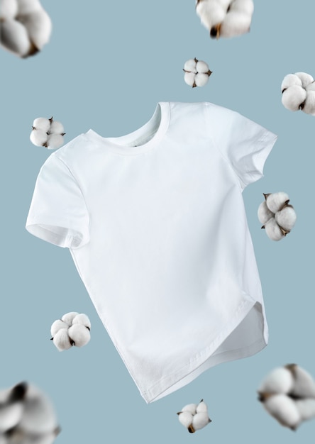 White flying cotton t-shirt isolated on blue background. clean\
white t-shirt for women or men. unisex. cotton flowers. branding\
clothes front view. mock up for your design. classic white basic\
t-shirt