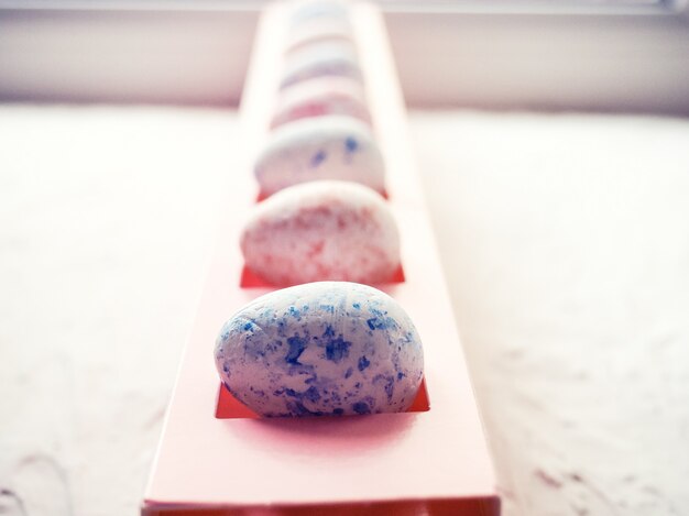 White foam eggs on blue background. Flat lay, top view. Easter concept.