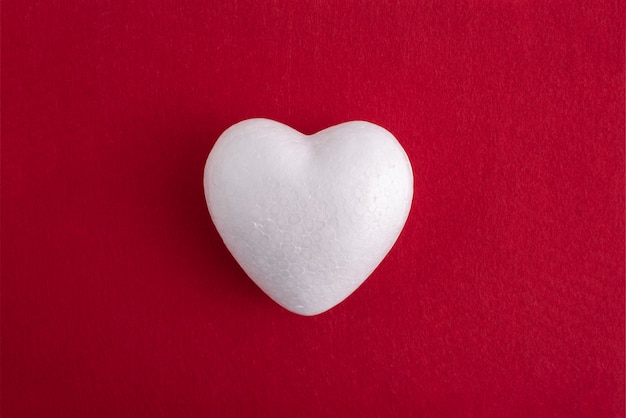 White foam heart on a red felt background