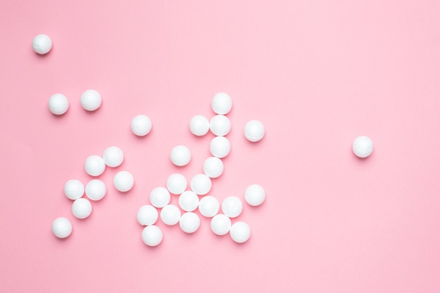 White foam plastic balls on pink  