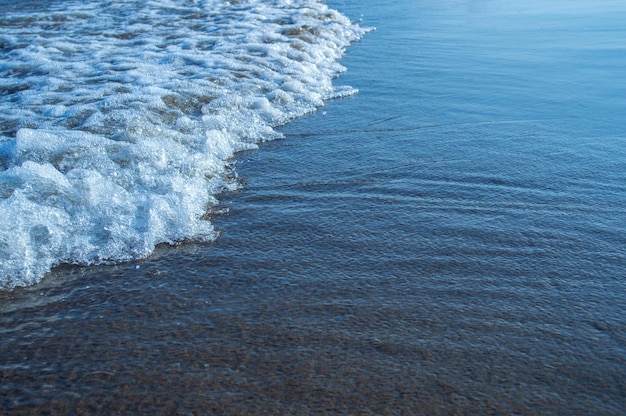 White foam on the surface of the wave comes ashore