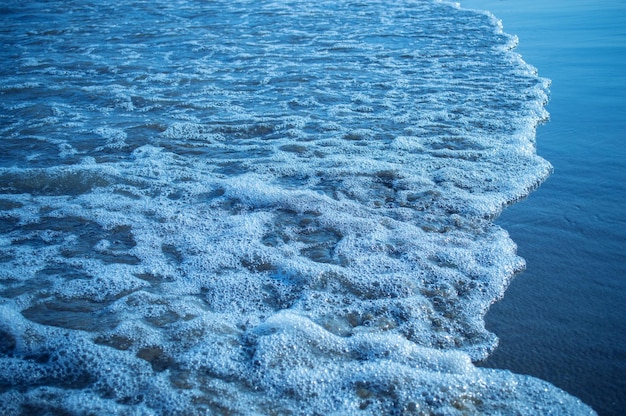 White foam on the surface of the wave comes ashore