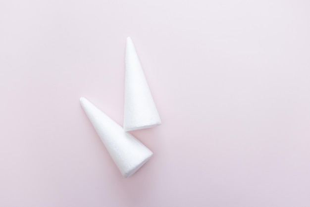 Photo white foam triangle base for arts and crafts supplies on a pale pink background