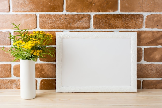 White frame mockup with yellow flowers near exposed brick walls