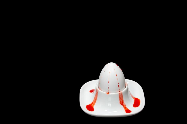 Photo white fresh hens egg in egg cup spot of red egg colouring