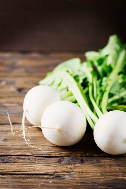 White fresh turnip on the wooden table