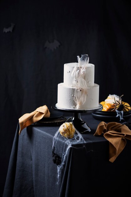 White frosting cake with Halloween decoration on the black table, selective focus image