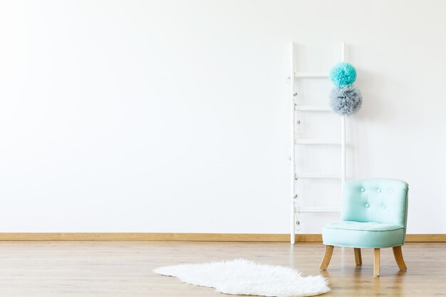 White fur next to blue chair in empty boy's room interior with copy space and ladder real photo