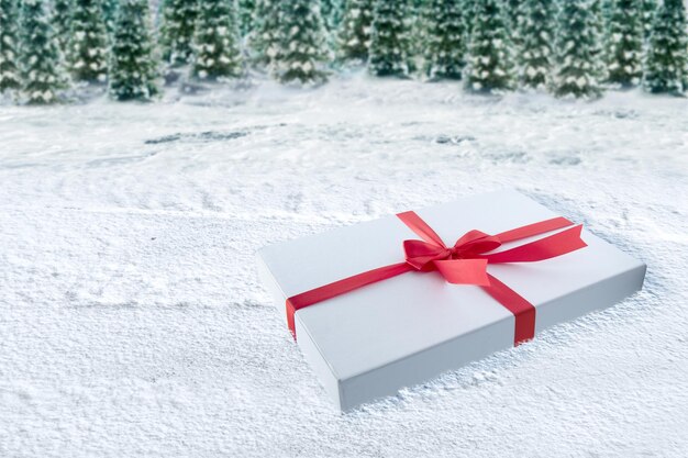 Photo white gift box cap with red ribbon on the snow